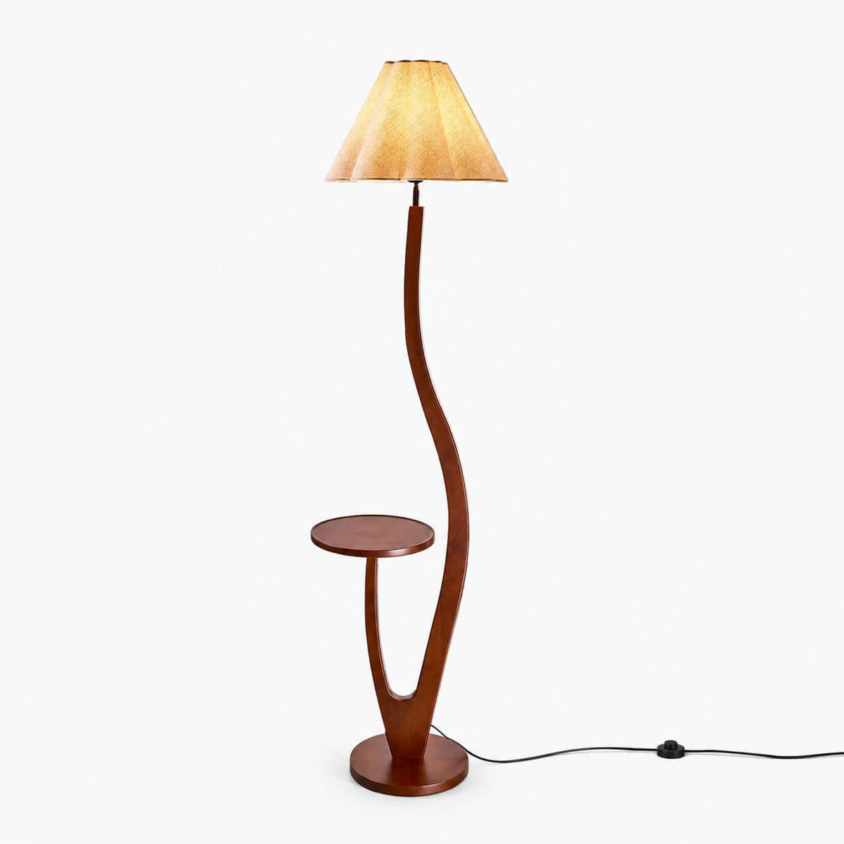 Curved dark-wood floor lamp with a round tray table partway down the stem and a pleated cream shade, shown on white for this Clérachic lamp.