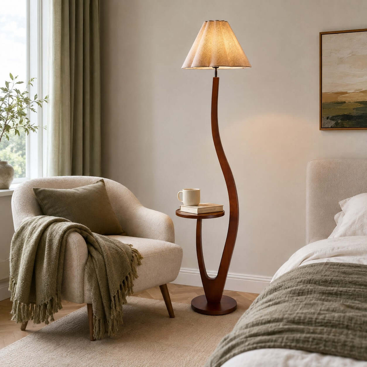 Pleated shade on this Clérachic floor lamp in a reading corner with a green throw on a cream armchair and a bed behind.