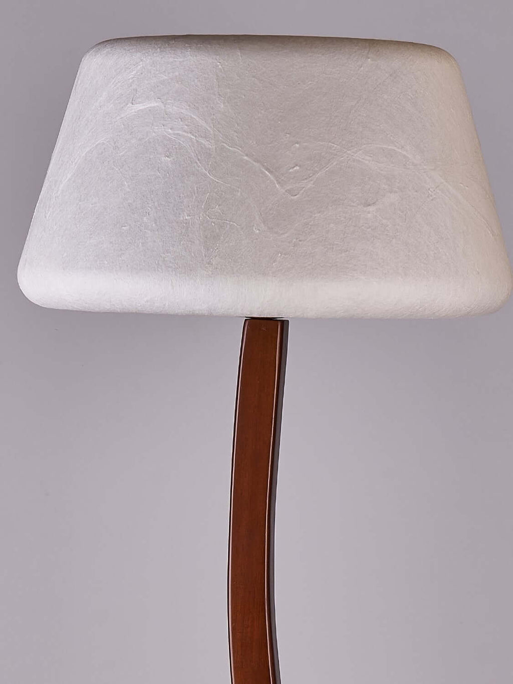Close view of the rounded, textured white shade on this Clérachic floor lamp, above the curved wooden stem.