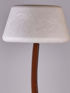 Close view of the rounded, textured white shade on this Clérachic floor lamp, above the curved wooden stem.