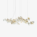 Clérachic gingko chandelier on white, porcelain and gilt leaves along a long branch frame.