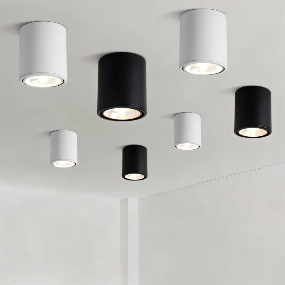 Clérachic cylinder downlights in black and white and in two sizes, scattered across a pale ceiling and all switched on.