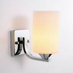 Clérachic polished chrome glass cylinder wall sconce, lit, shown against a plain wall in a close studio shot.