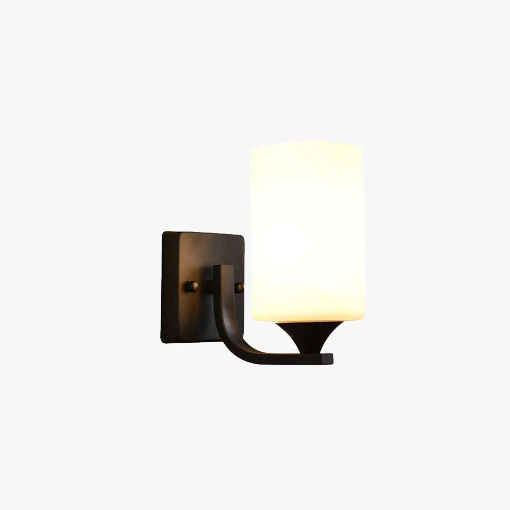 Studio shot of the Clérachic black glass cylinder wall sconce, lit, on a plain grey background.