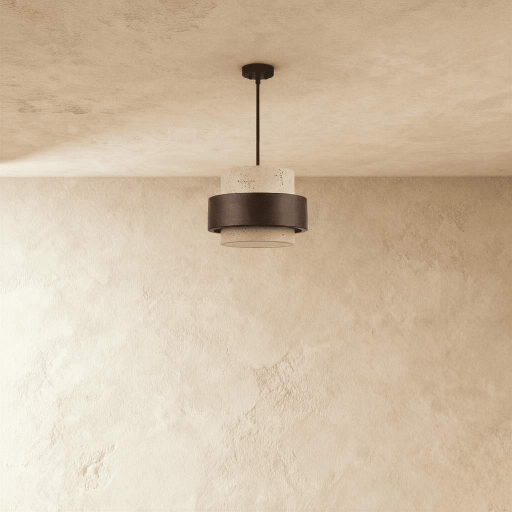 Clérachic travertine drum pendant with a dark wood band, switched off and hung from a black rod over a textured plaster wall.