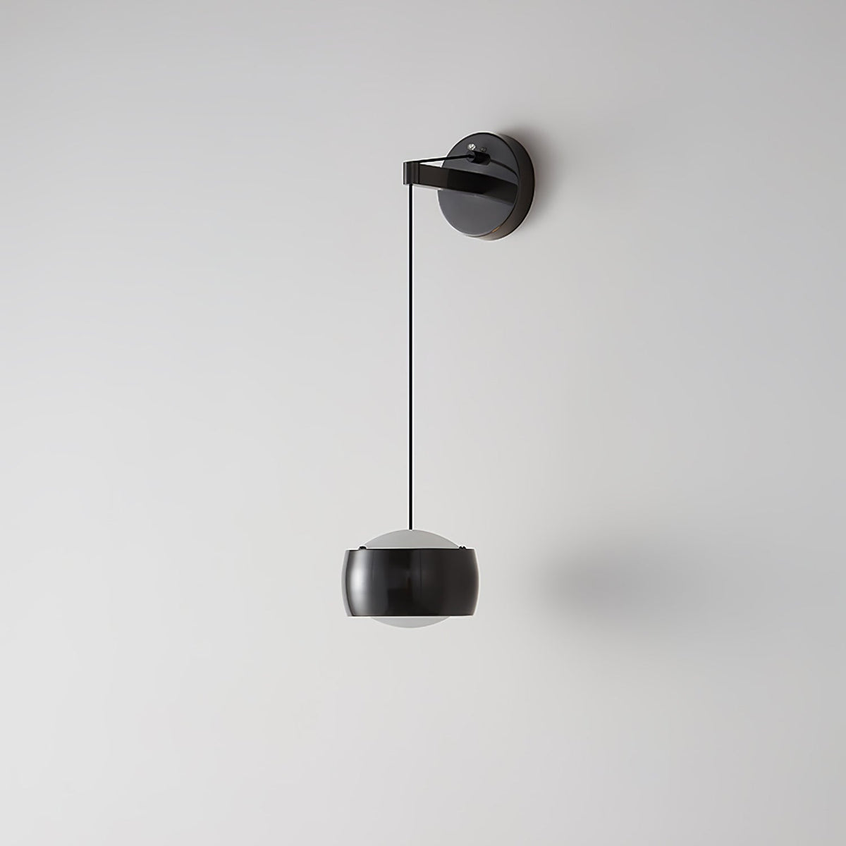 Black Clérachic wall light on a light grey wall, its glossy cylinder shade hanging below a round backplate on a thin cable.