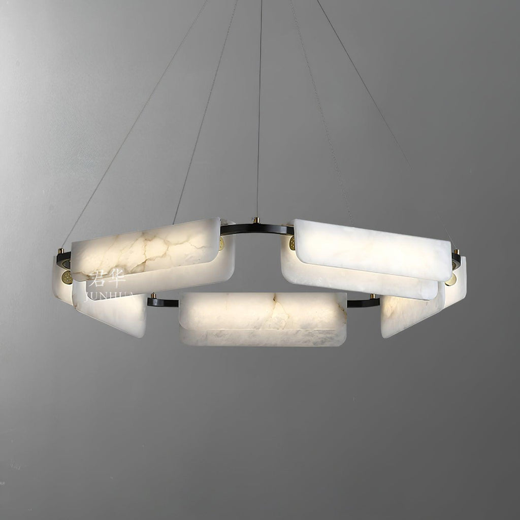The Clérachic Delia chandelier lit on grey, its alabaster blocks glowing around the dark frame.