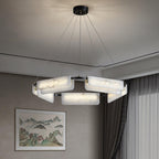 The Clérachic Delia chandelier lit in a room with a framed landscape painting and long curtains.