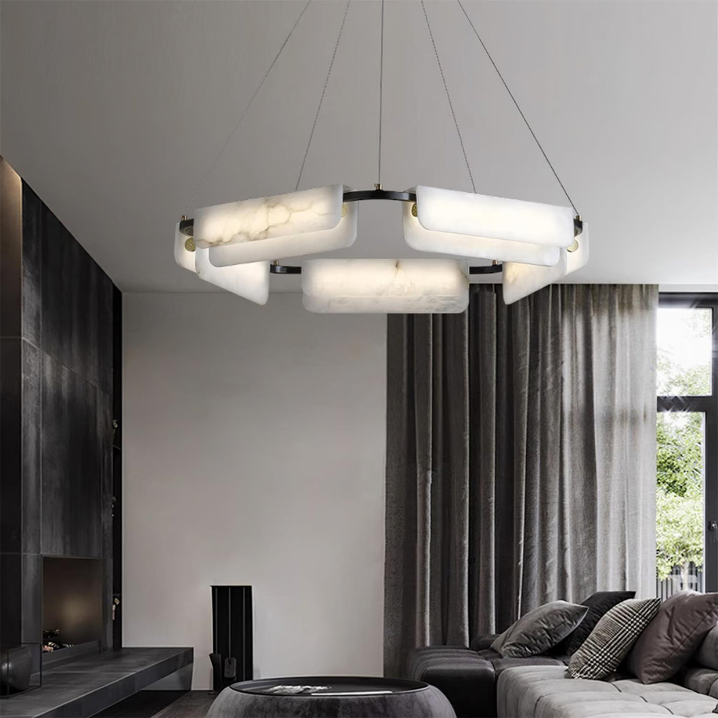 Clérachic Delia chandelier lit in a dark living room with grey drapes and a stone fireplace.