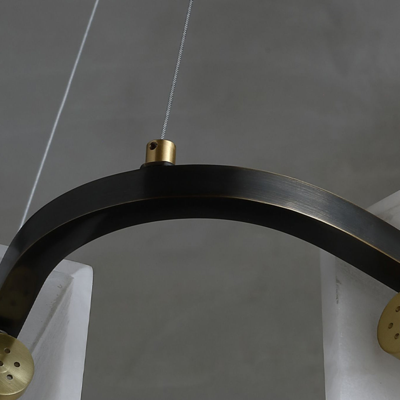 Detail of the Clérachic Delia chandelier's blackened metal ring meeting a brass cable fitting.
