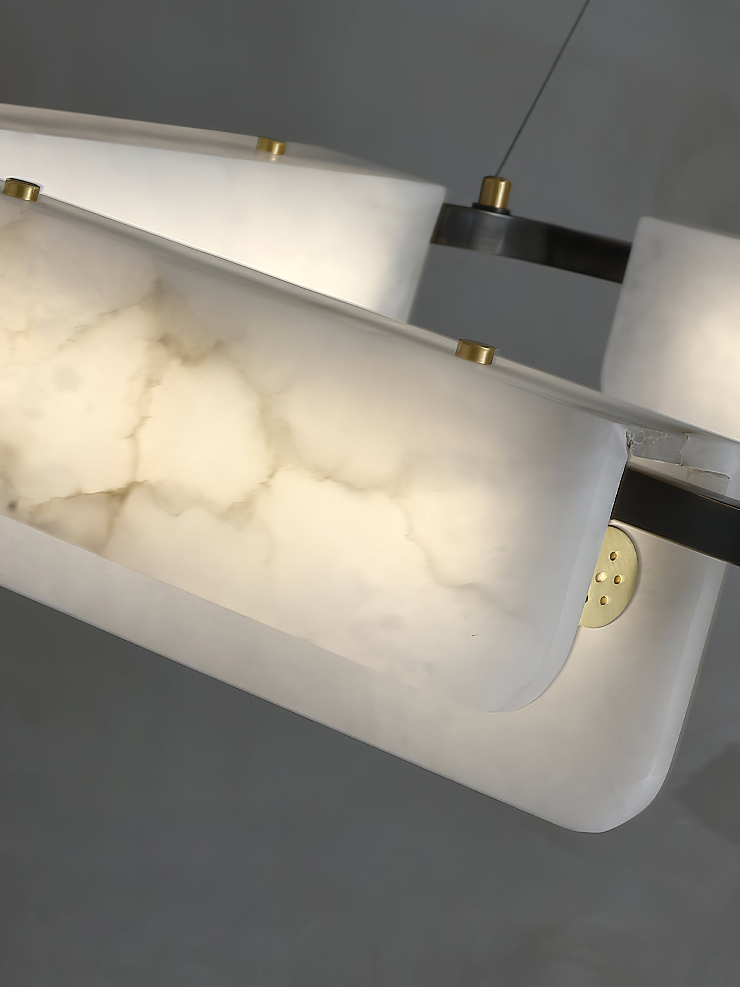 Lit alabaster panels on the Clérachic Delia chandelier, the stone's veining glowing warm from behind.