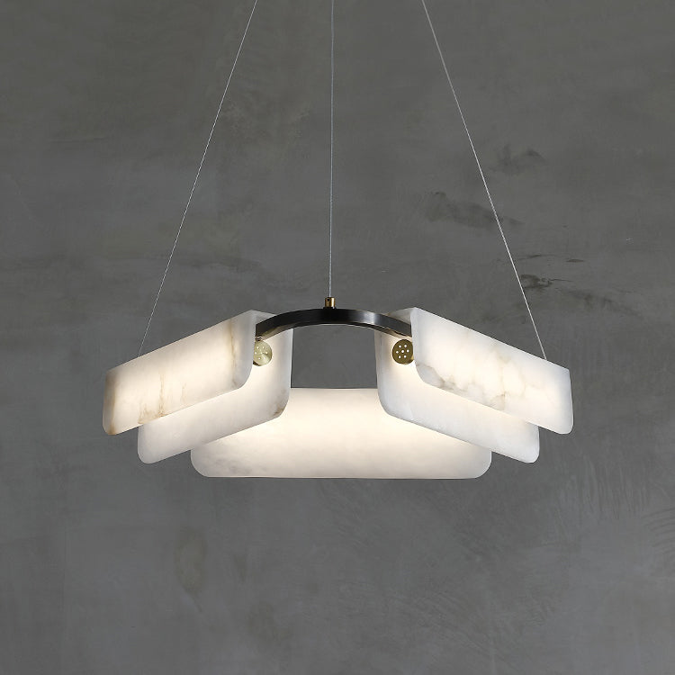 The three-head Clérachic Delia chandelier lit head-on, warm light spilling through the alabaster.