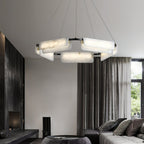 Clérachic Delia chandelier lit in a living room with floor-length curtains and a corner sofa.