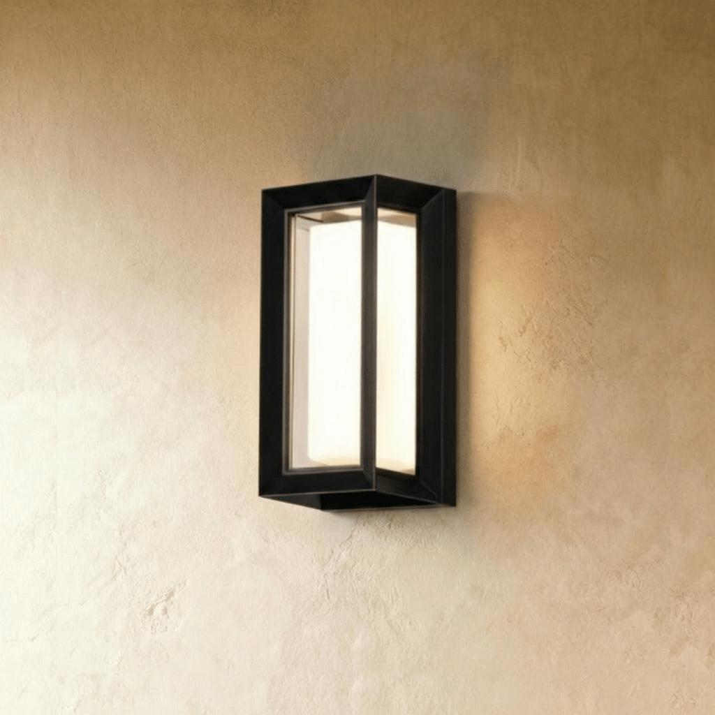 Clérachic black outdoor wall lamp with a fully framed rectangular body and a glowing white diffuser, on a plaster wall