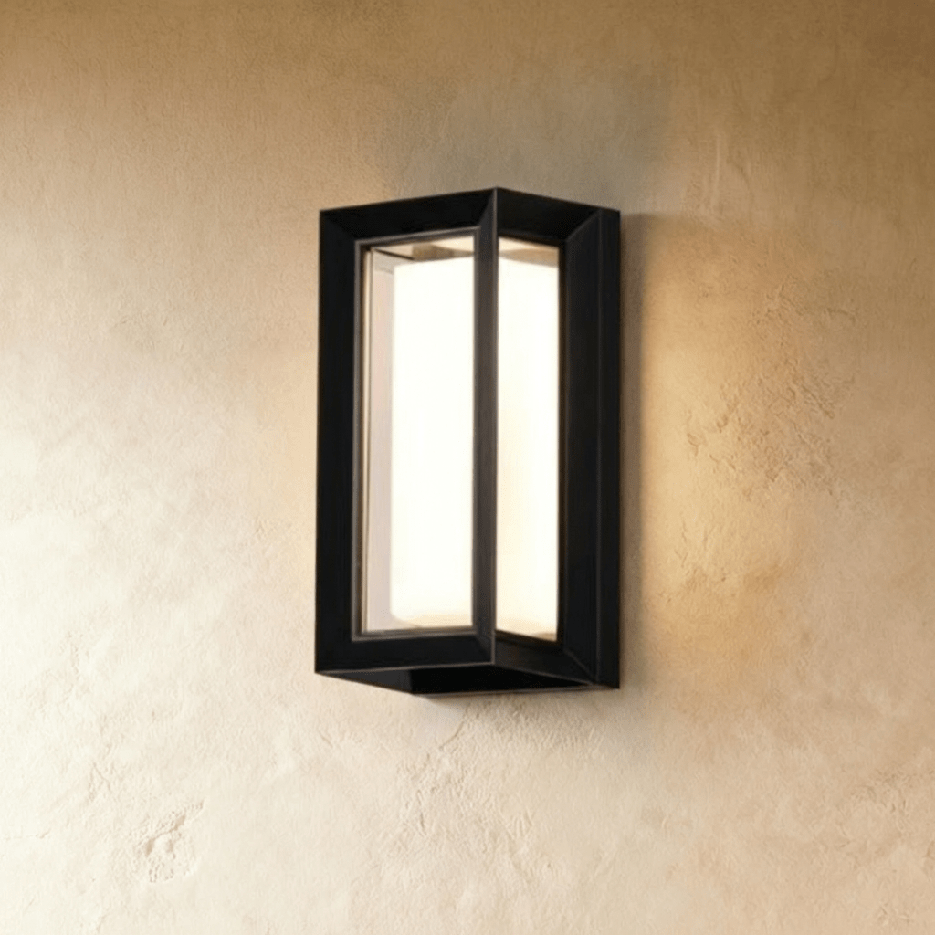 Clérachic larger black framed outdoor wall lamp with a glowing white diffuser, mounted high on a plaster wall