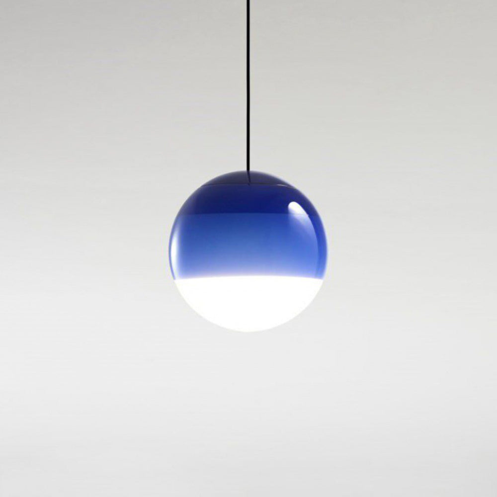 The Clérachic dipped gradient glass pendant light in cobalt blue, hanging alone against a pale studio wall.