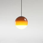 Clérachic dipped gradient glass pendant light in warm amber, the colour deepening from the opal white base up to the crown.