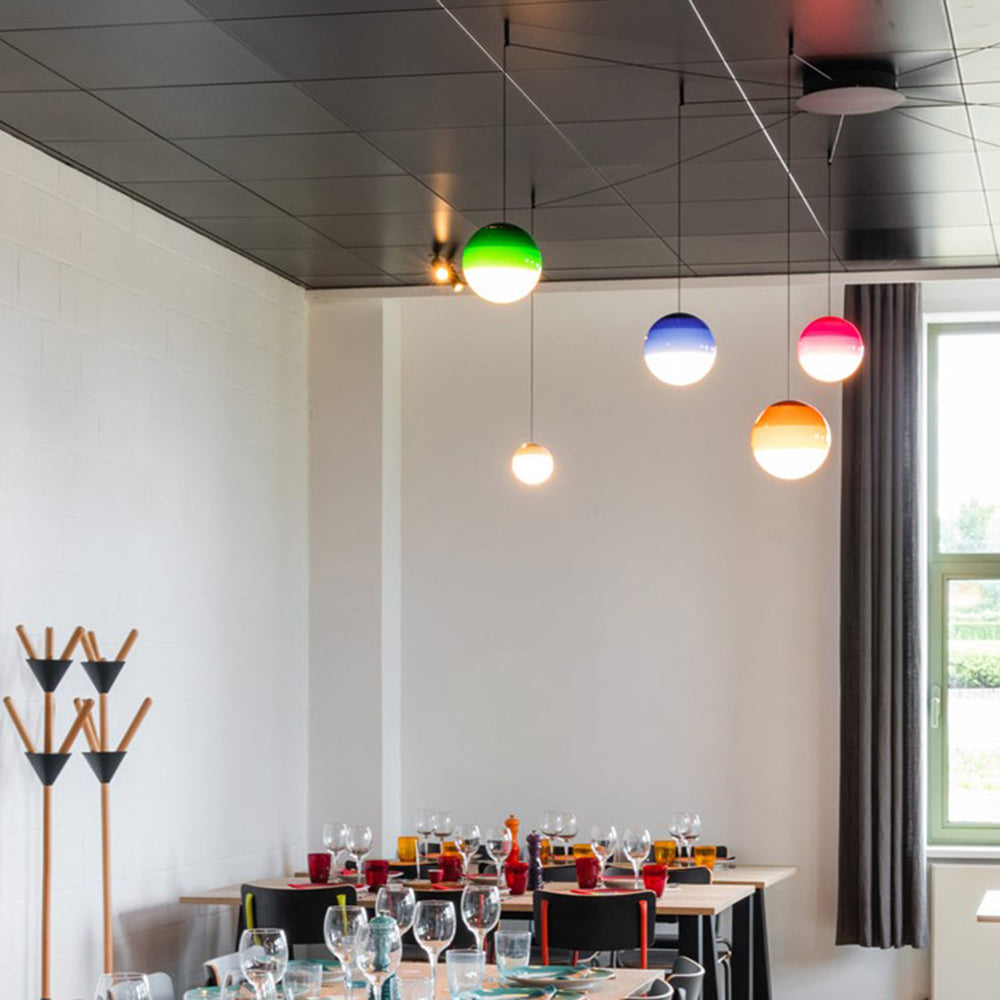 Clérachic dipped gradient glass pendant lights in six colours hanging over long dining tables in a bright canteen.