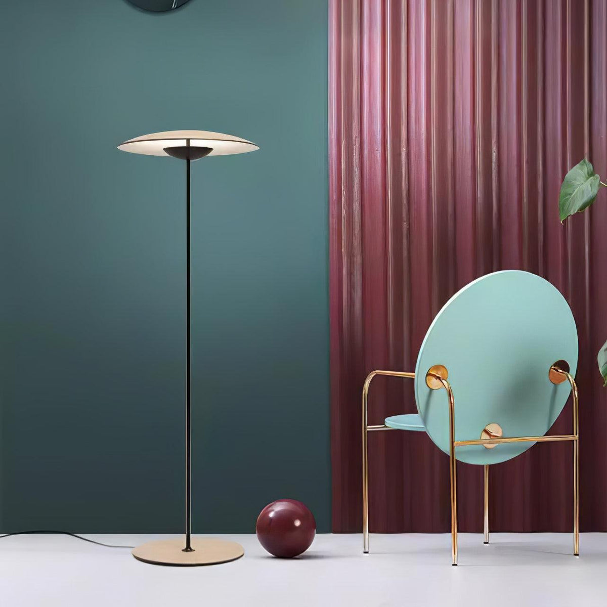 A Clérachic floor lamp stands against a teal wall and a pink pleated curtain, beside a pale-blue round-backed chair.