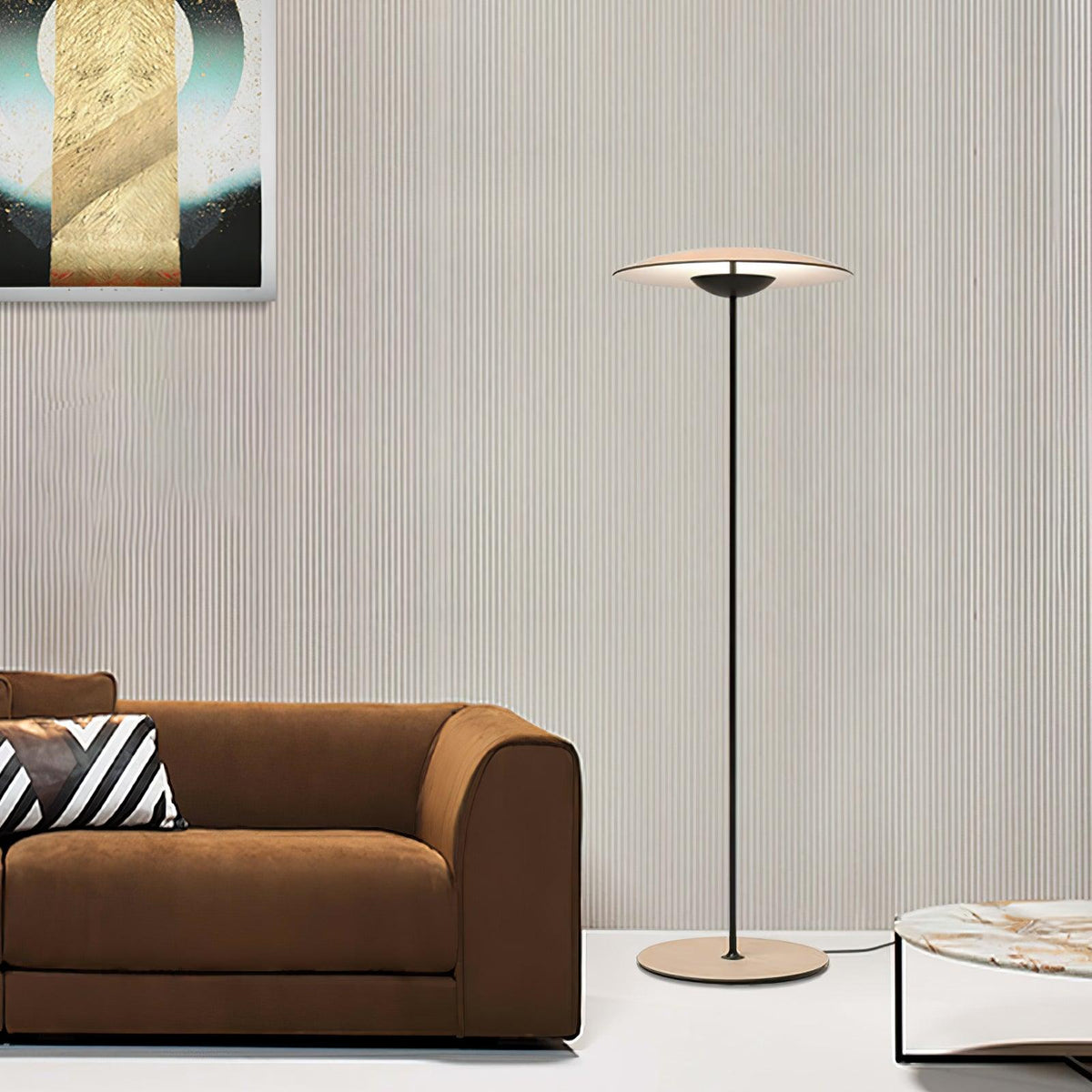 A Clérachic floor lamp stands in front of a ribbed wall beside a brown sofa with a striped cushion and a marble table.