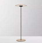 Front view of this Clérachic floor lamp against a soft grey backdrop, its shade lit from underneath and its base wood grain.
