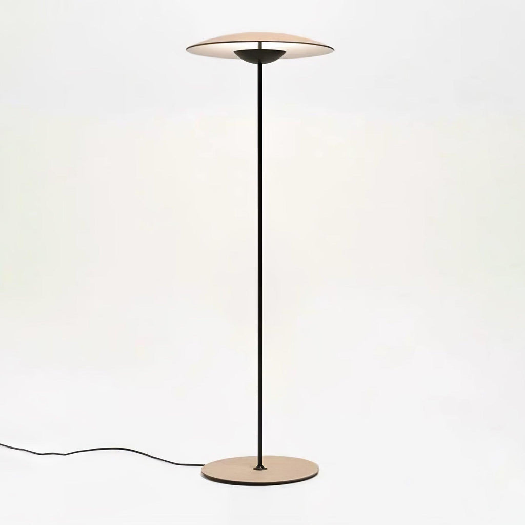 This Clérachic floor lamp on a pale backdrop, with its black cord trailing along the floor from the round base.
