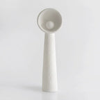 White Clérachic floor lamp with a rough, hand-formed finish and a round bulb in the bowl, on a pale grey backdrop.