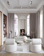 White Clérachic floor lamps in a tall, bright sitting room with arched windows, curtains and cream armchairs.