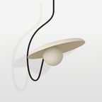 Clérachic cream metal disc pendant with an opal glass globe tucked beneath it, on a looping black cord, studio shot.