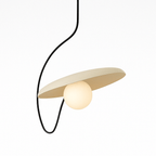 Clérachic pendant light with a tilted cream disc and a glowing opal globe, hung from a free-form black cord on white.