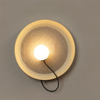 Round cream-rimmed Clérachic wall light with a textured glass centre, an opal globe and a black cord loop.
