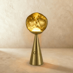 Clérachic gold table lamp with a rippled glass shade glowing warm above a brushed brass conical base and touch button.