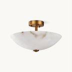 This Clérachic semi-flush ceiling light on a plain white backdrop, a veined alabaster dome under an antique brass canopy.