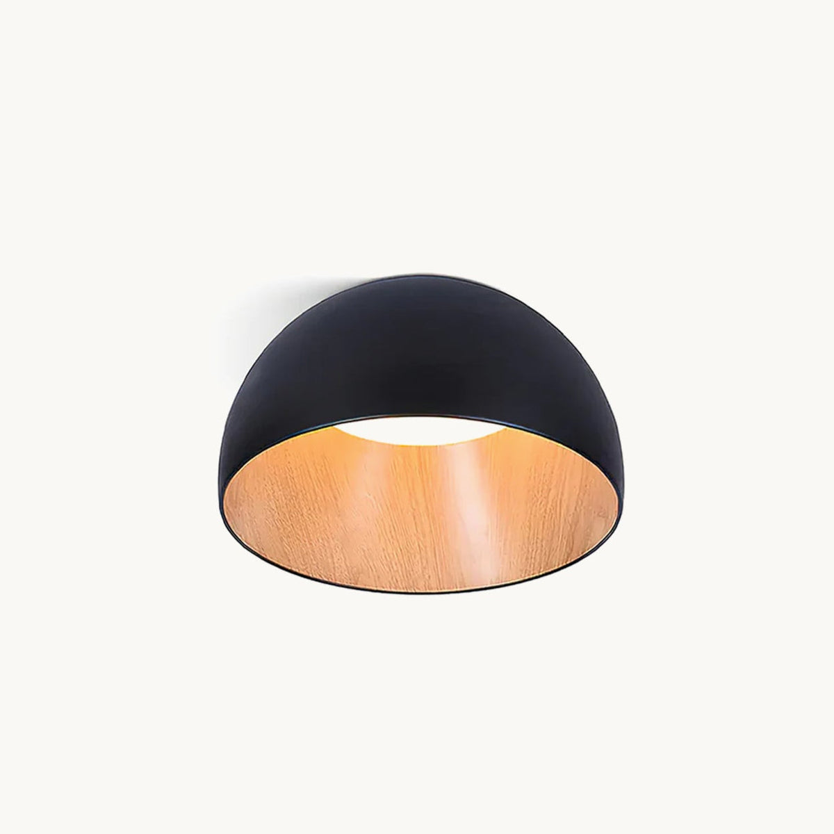 A black Clérachic dome ceiling light with a wood-effect oak interior and a soft white glow at the centre, on a plain off-white backdrop.