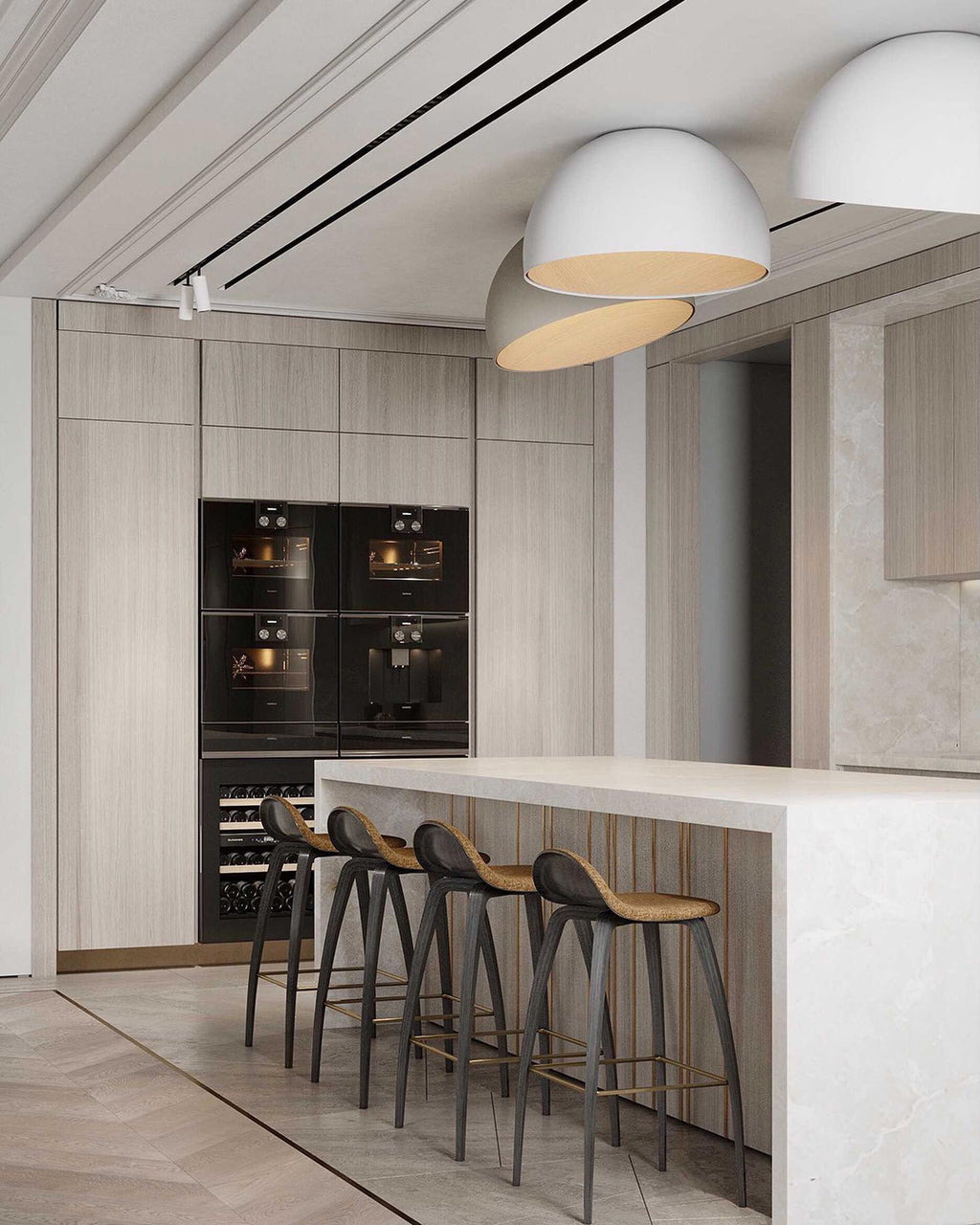 White Clérachic dome ceiling lights angled over a kitchen with tall oak cabinets, black ovens and a marble island with bar stools.