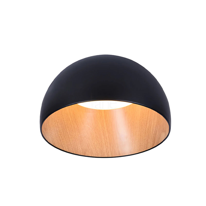 Large black Clérachic dome ceiling light seen from below, with the wood-effect interior and a white disc of light, on white.