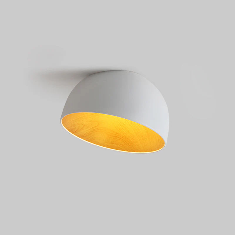 A white Clérachic dome ceiling light with a pale grey outer shell and wood-effect interior, set against a plain grey backdrop.