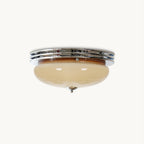 This Clérachic flush-mount ceiling light on a plain white background, with a beige glass dome under a triple chrome trim ring.