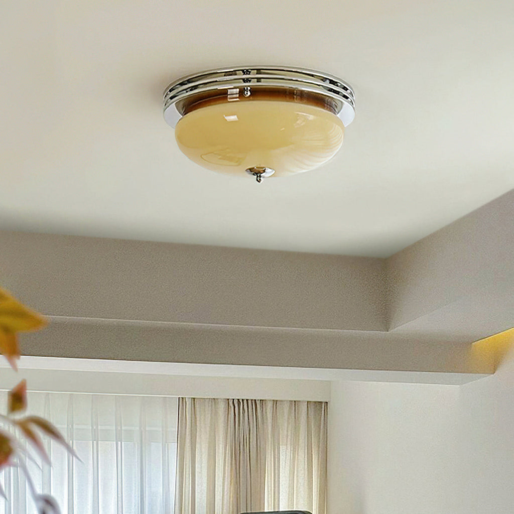 Clérachic flush-mount light sitting close to the ceiling beside a stepped plaster ceiling edge, with soft curtains in the background.