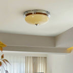 Clérachic flush-mount light sitting close to the ceiling beside a stepped plaster ceiling edge, with soft curtains in the background.