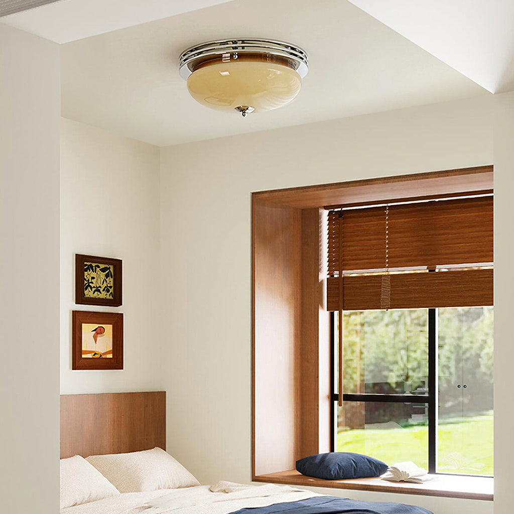 Bedroom with a Clérachic flush-mount ceiling light above a wood-framed window seat and a bed with a wooden headboard.