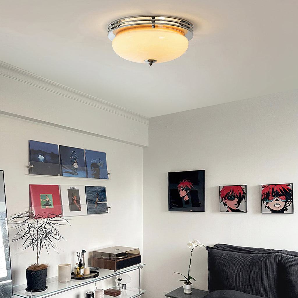 Living room with a Clérachic dome ceiling light above a record shelf, framed prints, a plant and a grey sofa.