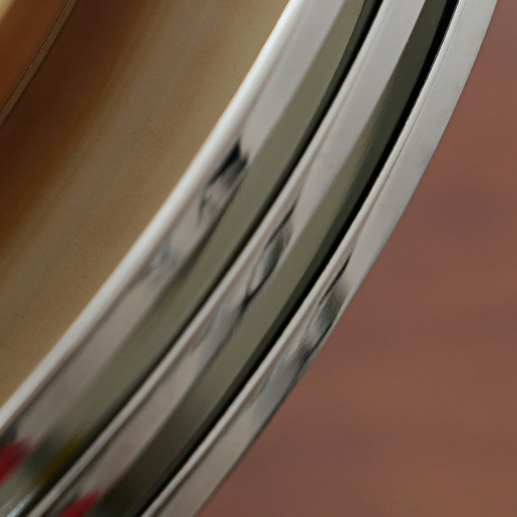 Close view of the chrome rings of this Clérachic ceiling light, their polished edges curving against a warm brown backdrop.