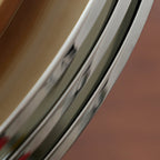 Close view of the chrome rings of this Clérachic ceiling light, their polished edges curving against a warm brown backdrop.