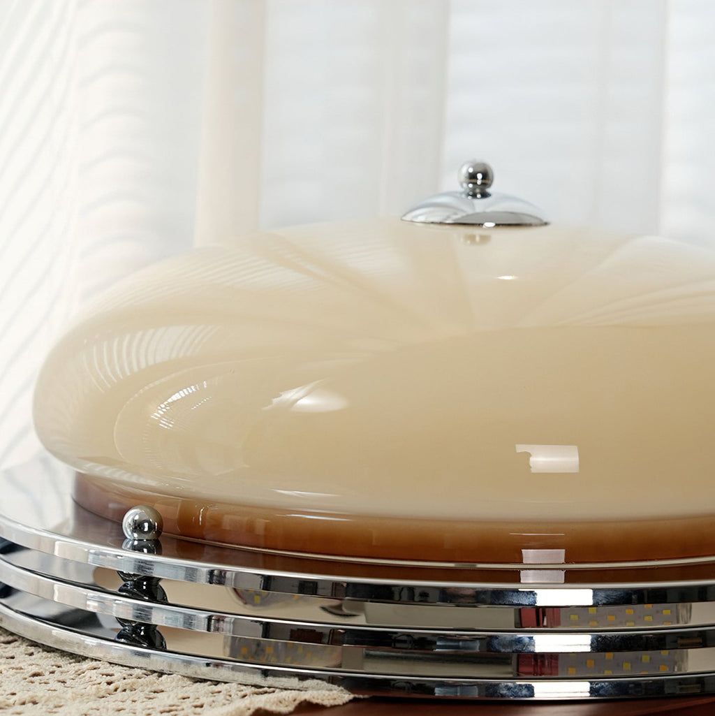 Low side view of this Clérachic ceiling light on a lace runner, showing the beige dome, chrome finial and stacked rings.