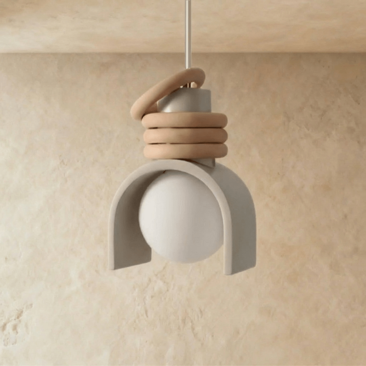 Clérachic pendant light in white, unlit, its pale arch shade cradling a matte globe under three stacked tan rings