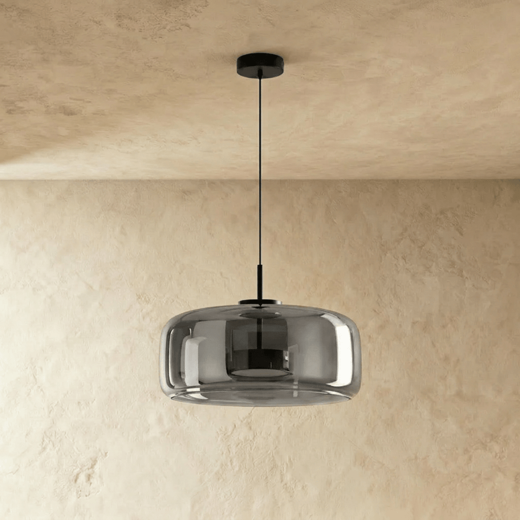 Clérachic wide smoked glass dome pendant switched off, black canopy and cord, against a textured limewash wall.
