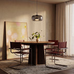 Clérachic wide smoked glass pendant hung above a round walnut dining table with leather chairs and linen curtains.