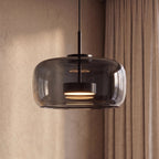 Clérachic close view of the wide smoked glass dome, black stem and a lit disc diffuser inside, beside linen curtains.