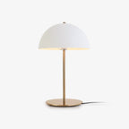 White dome-shade table lamp from Clérachic on a slim brass stem and round base, shown on a plain light backdrop.